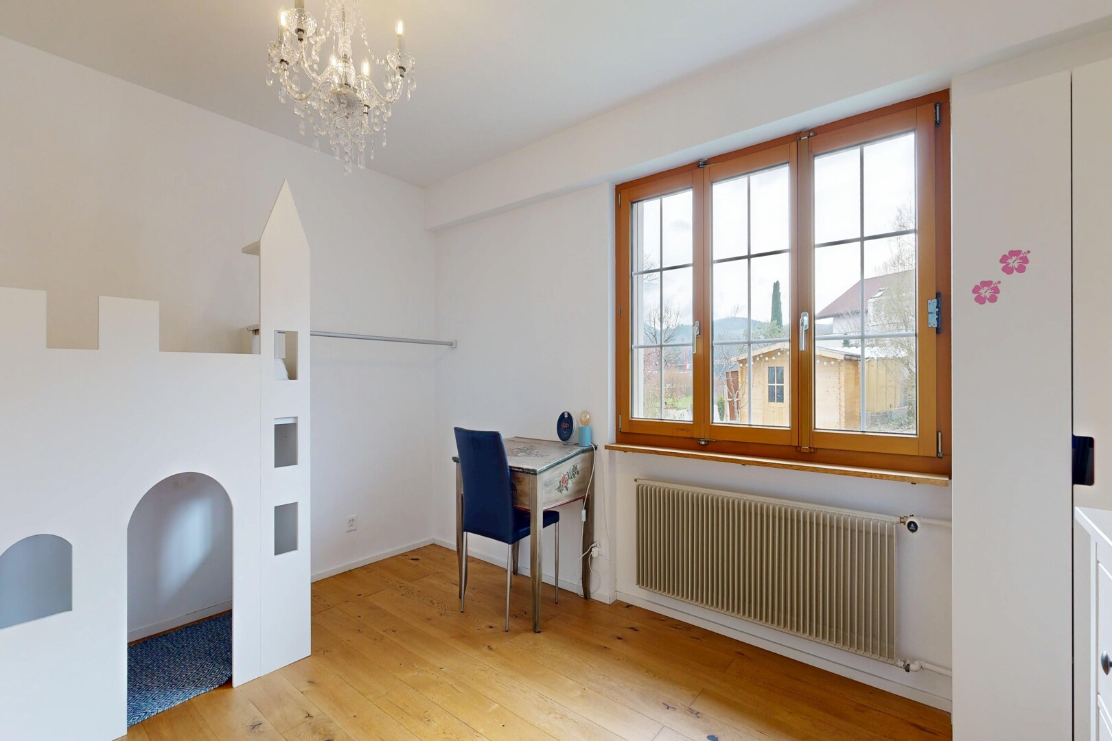 chambre avec radiateur, sol en finition bois, wood finish floor, inside community, et lustre remarquable