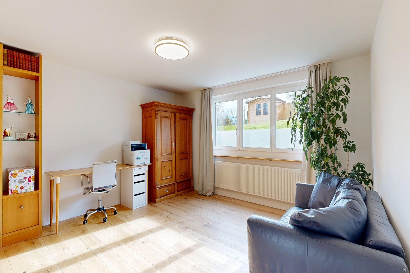 bureau avec espace bureau, sol en finition bois, wood finish floor, inside property, et lumière naturelle