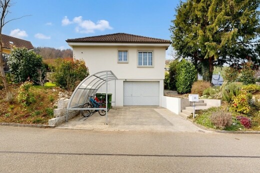 außenansicht mit property visible, eingebaute garage, stuckverkleidung, day time, und auffahrt