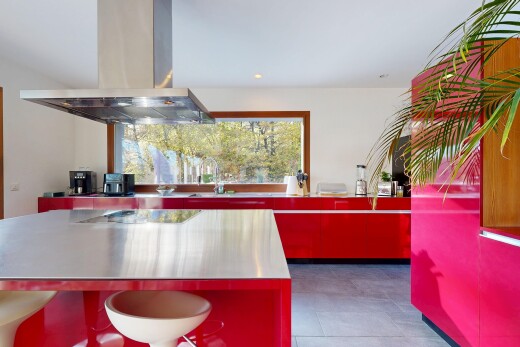 küche mit edelstahl-arbeitsplatten, rote schränke, dunstabzugshaube, natural light, und natürliches licht
