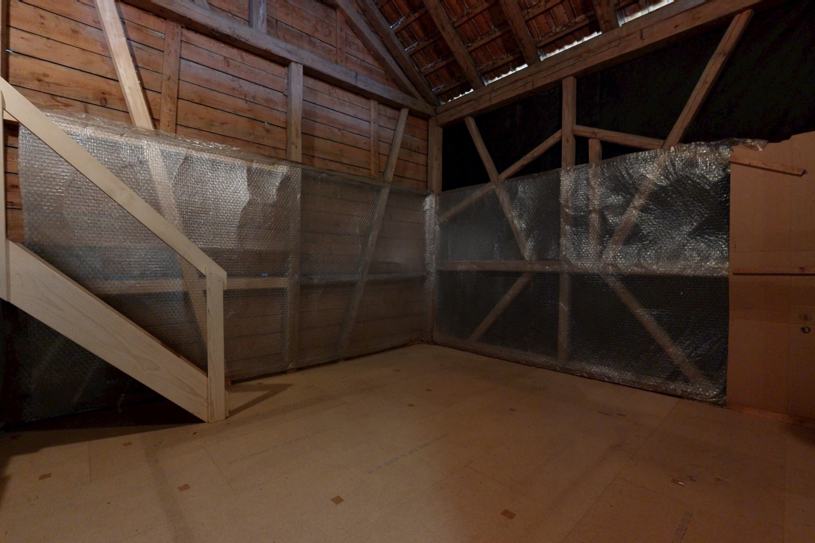 pièce vide avec inside property, unfinished floor, plafond voûté, et vaulted ceiling