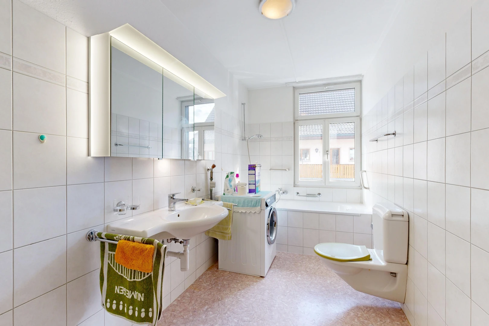 salle de bains avec toilette, salle de bain complète, miroir, mur en carrelage, et tile wall