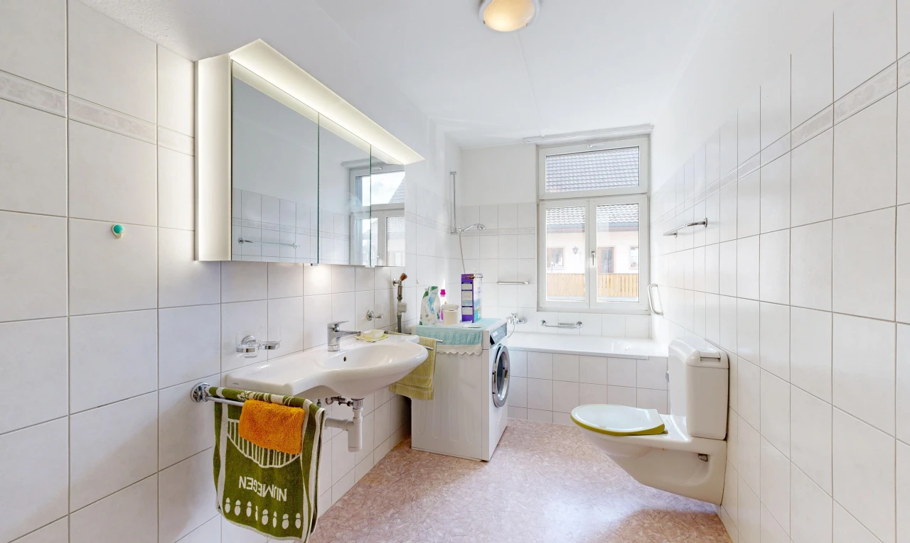 salle de bains avec toilette, salle de bain complète, miroir, mur en carrelage, et tile wall
