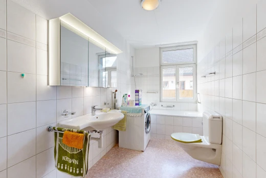 salle de bains avec toilette, salle de bain complète, miroir, mur en carrelage, et tile wall
