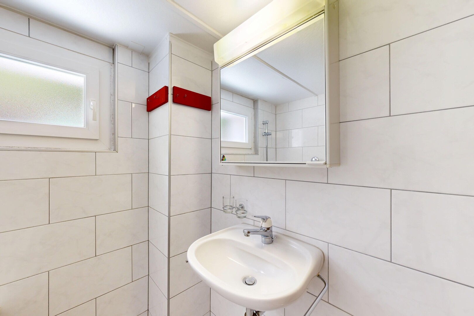 salle de bains avec évier, miroir, mur en carrelage, tile wall, et inside property