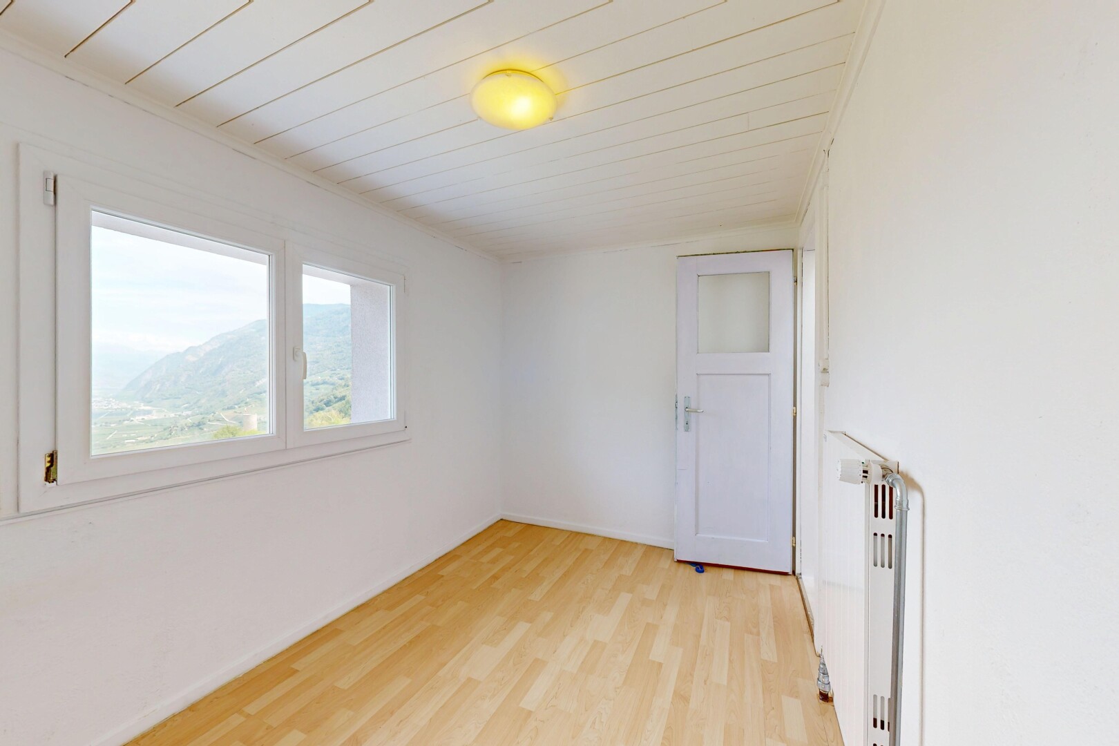 pièce vide avec drywall, cloison sèche, radiateur, inside property, et wood finish floor