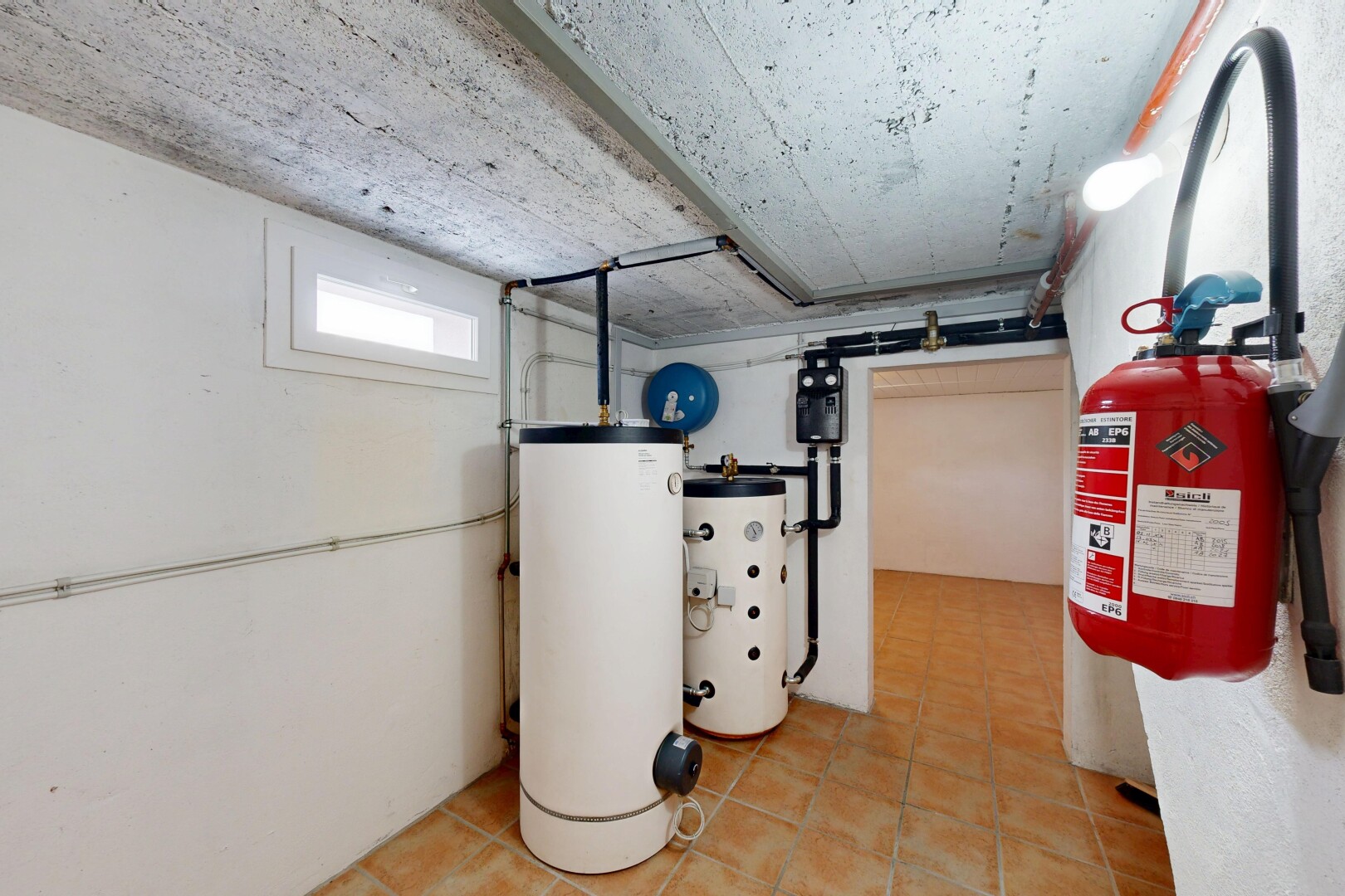 buanderie avec chauffe-eau, sous-sol, lumière naturelle, inside property, et drywall