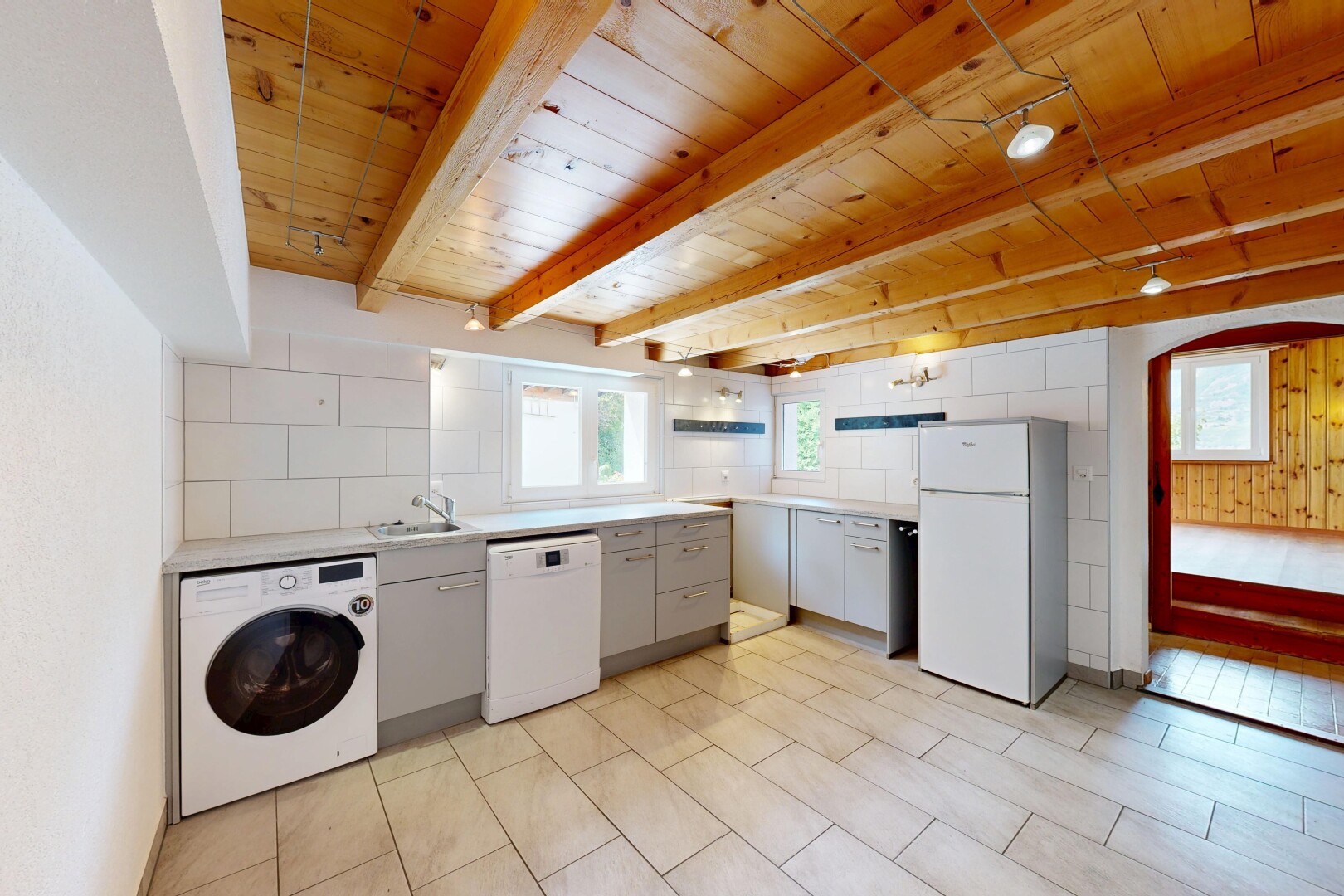 buanderie avec buanderie, lave-linge et sèche-linge, light floor, passages en arc, et wood ceiling