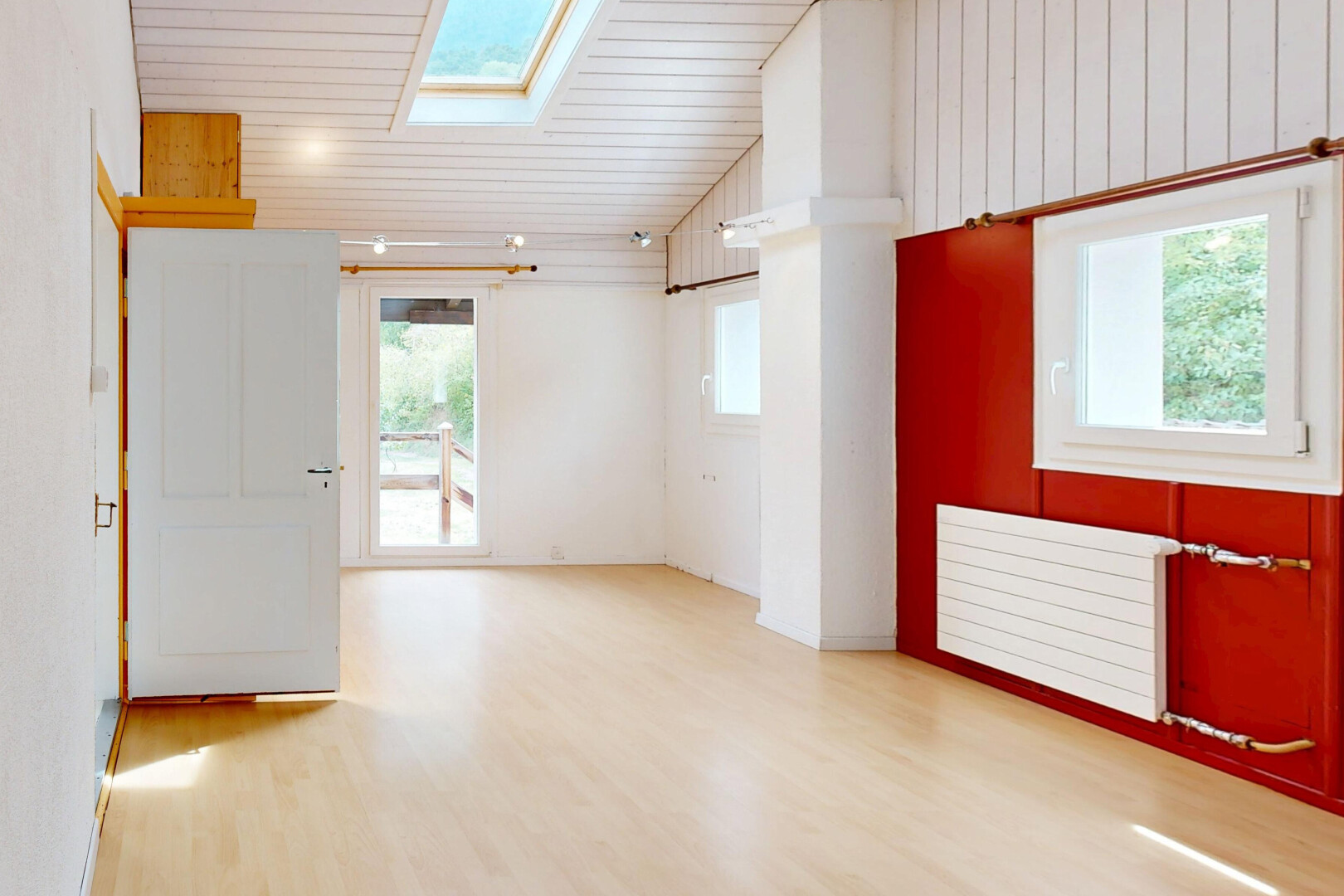 pièce vide avec puits de lumière, plafond voûté, vaulted ceiling, sol en finition bois, et wood finish floor