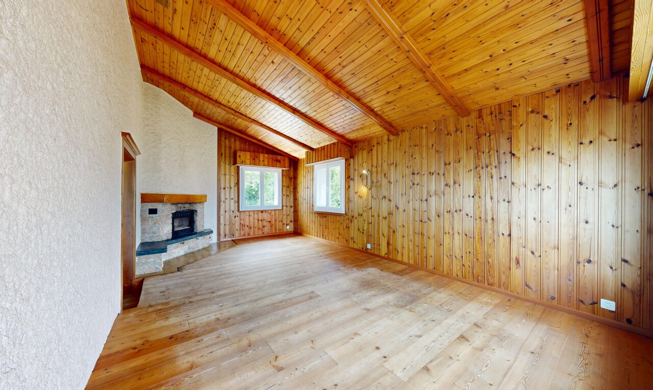 pièce vide avec vaulted ceiling, plafond voûté, beamed ceiling, plafond à poutres, et wood finish floor
