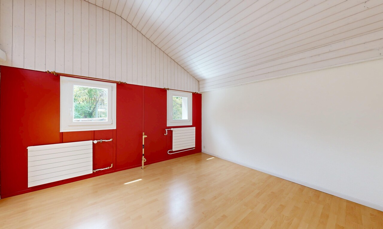 pièce vide avec vaulted ceiling, plafond voûté, radiateur, lumière naturelle, et wood finish floor