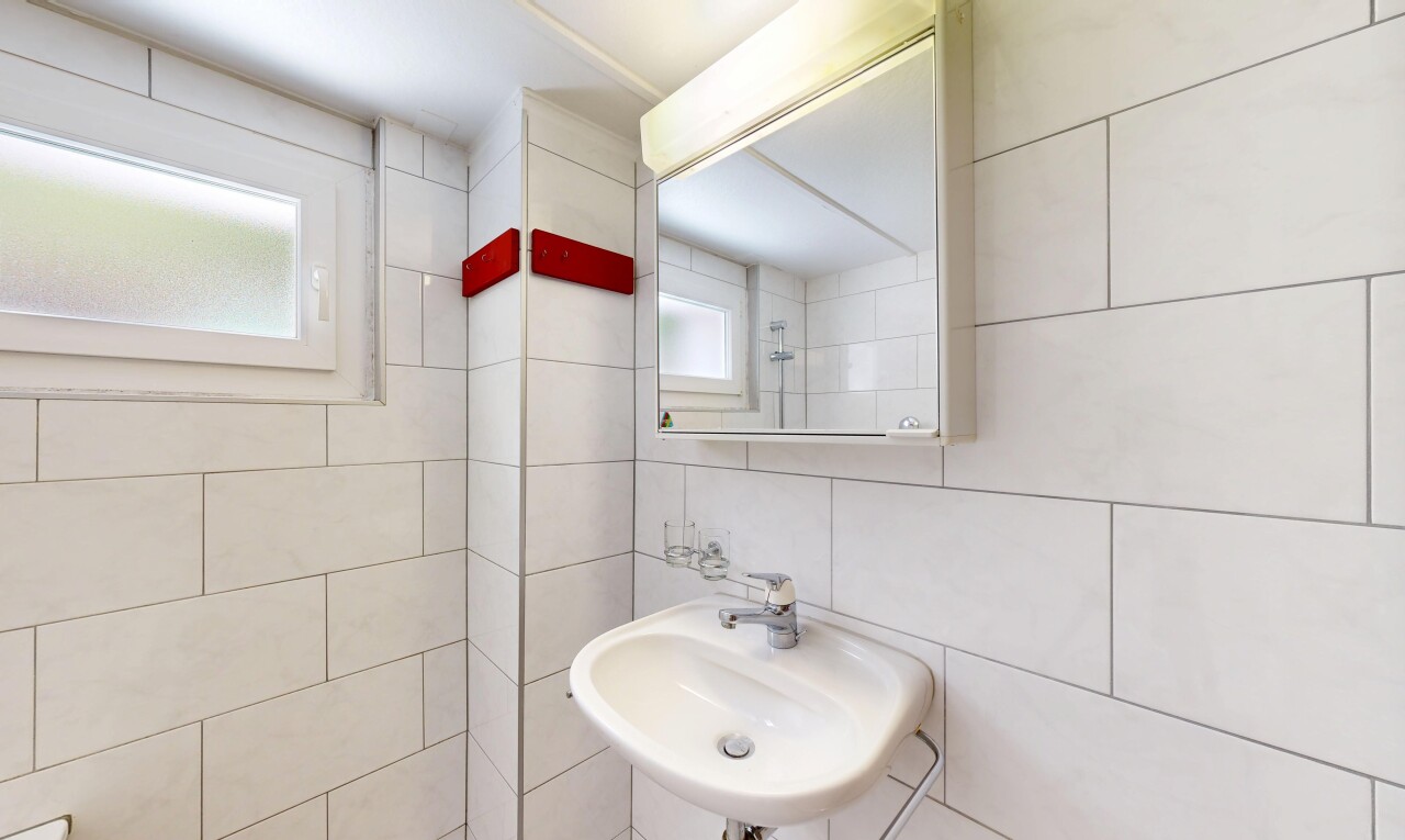 salle de bains avec évier, miroir, mur en carrelage, tile wall, et inside property