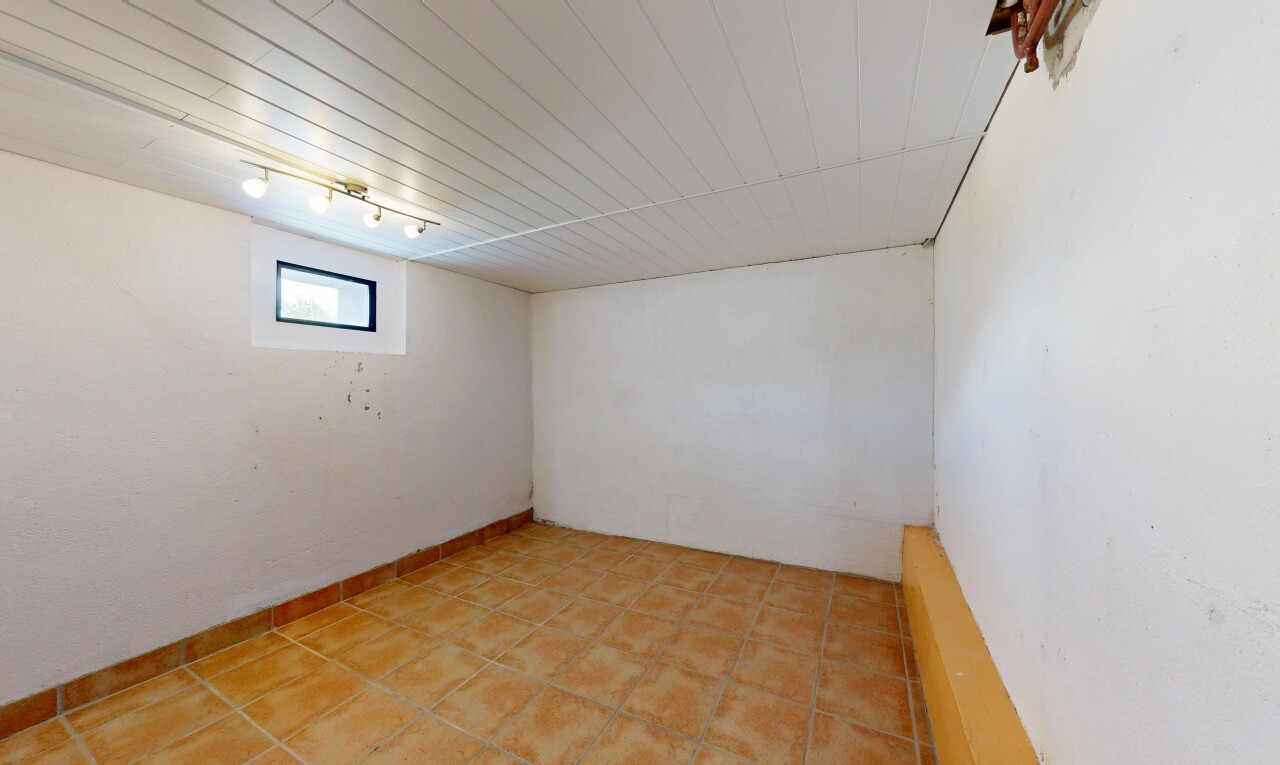 pièce vide avec éclairage sur rail, lumière naturelle, sous-sol, inside property, et cloison sèche