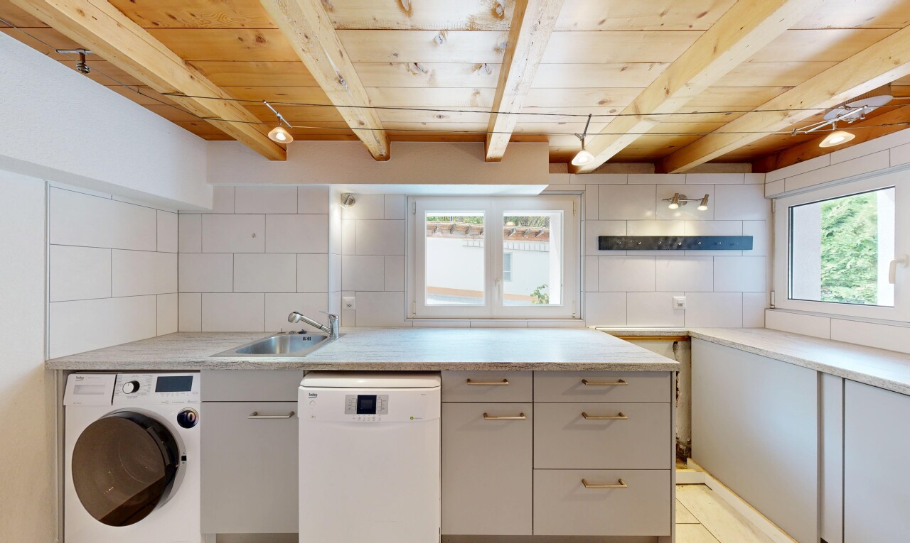 buanderie avec lave-linge et sèche-linge, plafond en bois, wood ceiling, évier, et plafond à poutres