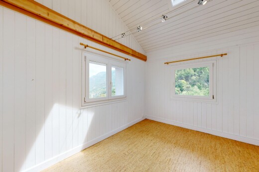 pièce vide avec wood wall, mur en bois, vaulted ceiling, plafond voûté, et lumière naturelle