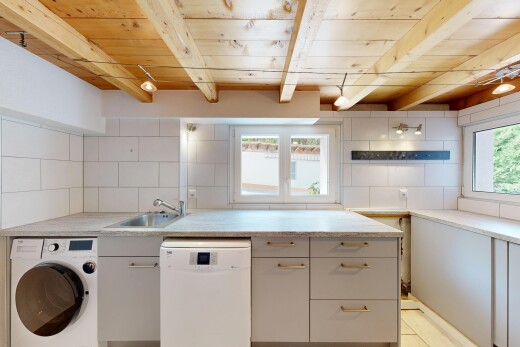 buanderie avec lave-linge et sèche-linge, plafond en bois, wood ceiling, évier, et plafond à poutres
