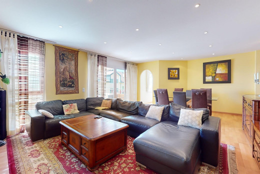 wohnzimmer mit parkettboden, gewölbte gehwege, und natürliches licht