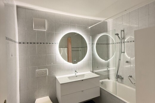 salle de bains avec salle de bain complète, lavabo (ou coiffeuse selon le contexte), miroir, mur en carrelage, et tile wall