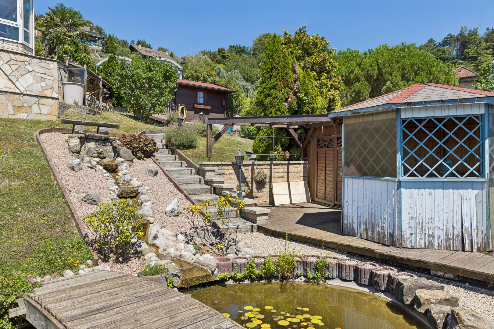 façade avec mur de soutènement en bord de l'eau, garden pond, étang de jardin, quai, et day time