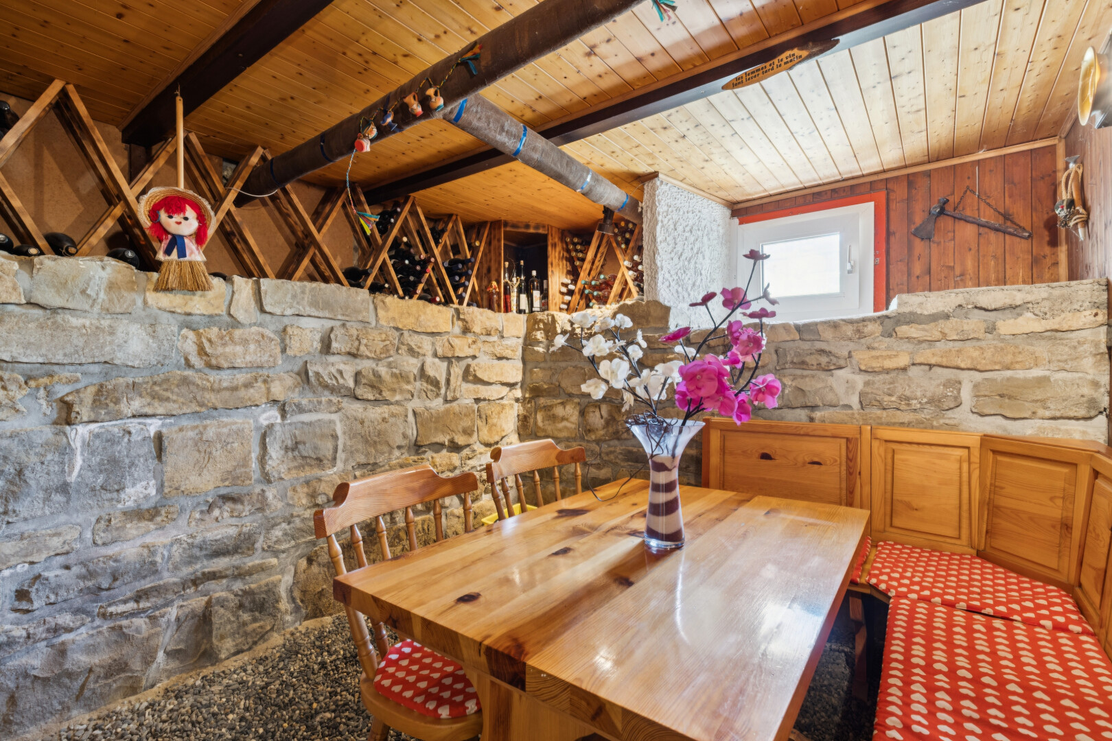 salle à manger avec plafond en bois, wood ceiling, mur en pierre, stone wall, et high end ceiling