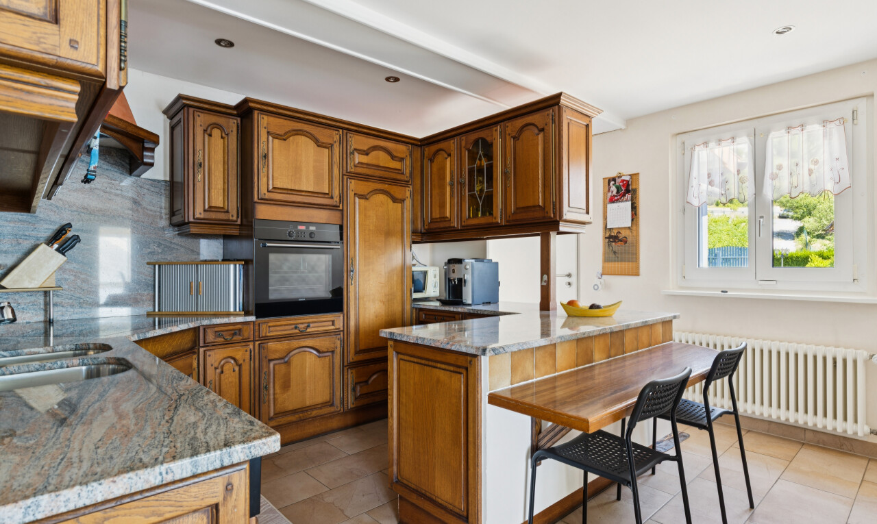 cuisine avec armoires en arc, arched cabinets, armoires avec insert en verre, glass insert cabinets, et plans de travail en pierre