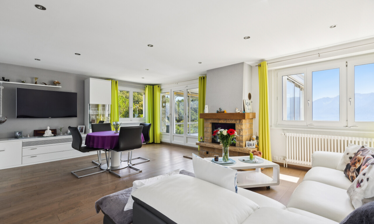 salon avec radiateur, télévision, éclairage encastré, lumière naturelle, et sol en finition bois