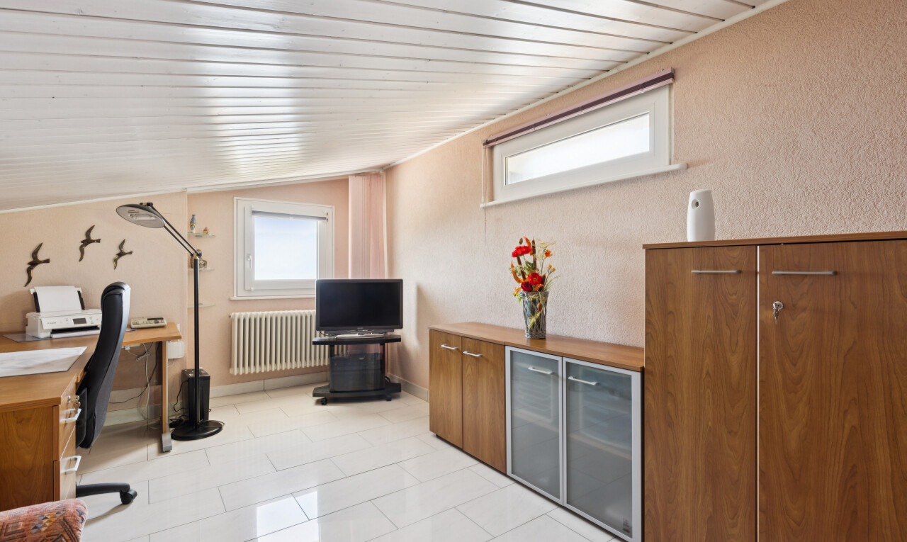 office featuring radiator heating unit, a textured wall, lofted ceiling, and light tile patterned floors