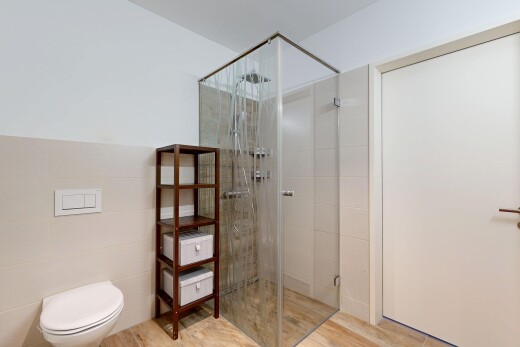 full bathroom with a shower stall, tile walls, and wainscoting