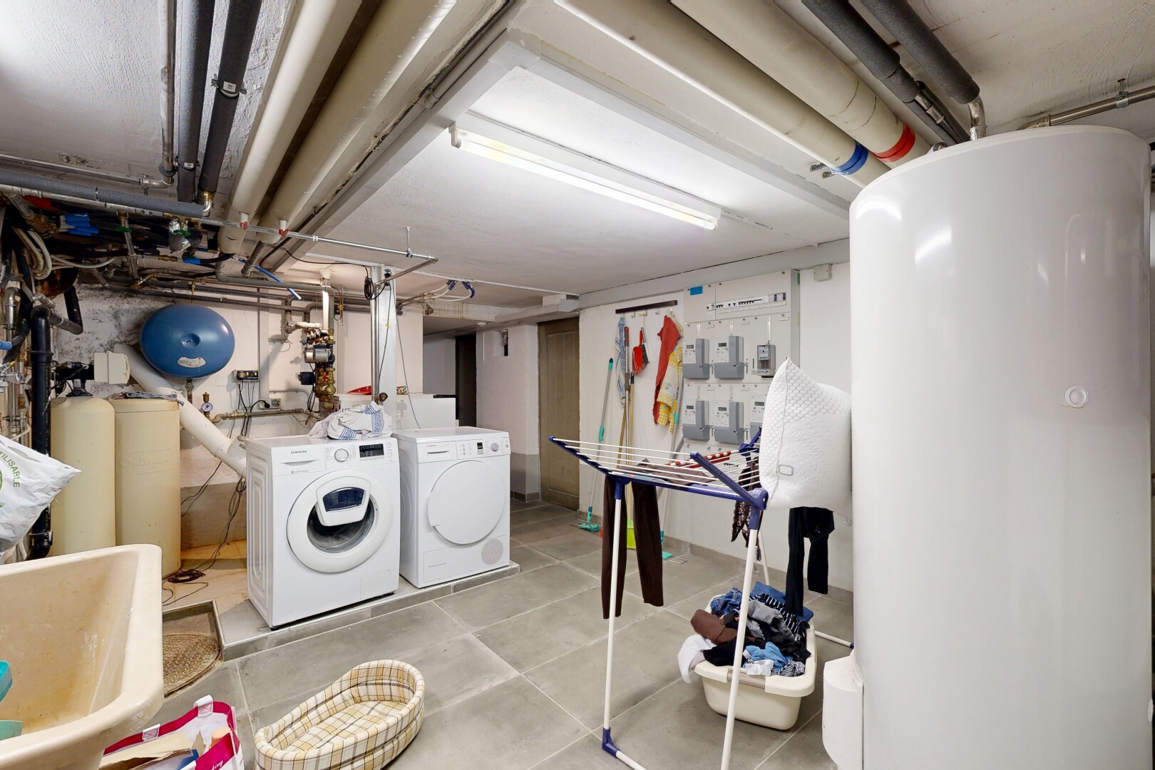 buanderie avec chauffe-eau, buanderie, inside property, lave-linge et sèche-linge séparés, et sous-sol