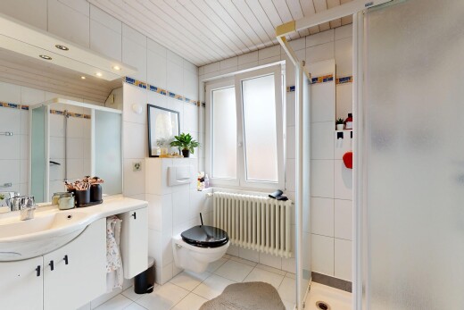 bathroom featuring radiator heating unit, vanity, a stall shower, tile walls, and light tile patterned flooring