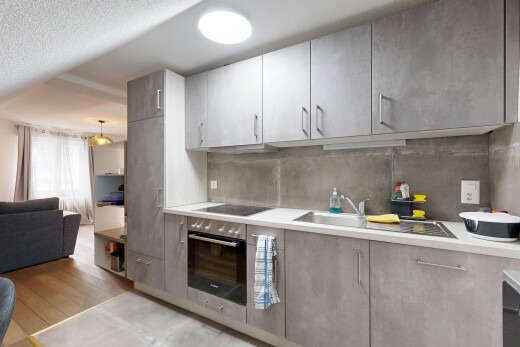kitchen featuring light countertops, open floor plan, stainless steel oven, light wood-style flooring, and a textured ceiling