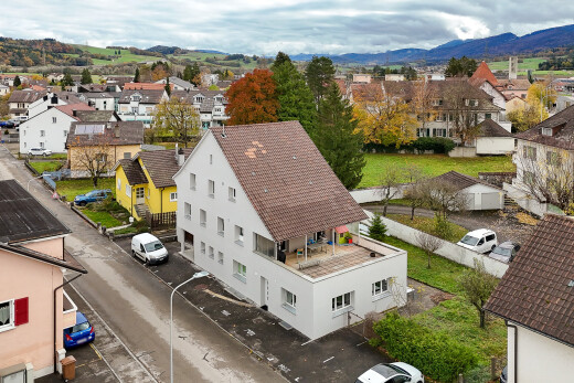 view of property with a residential view, a mountain view, a balcony, and stucco siding