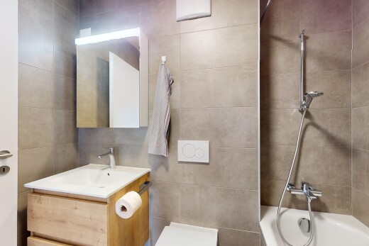 bad mit waschbecken, schminktisch, kombiniertes bad / dusche, fliesenwand, und spiegel