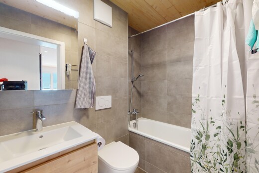 bad mit kombiniertes bad / dusche, schminktisch, waschbecken, spiegel, und fliesenwand