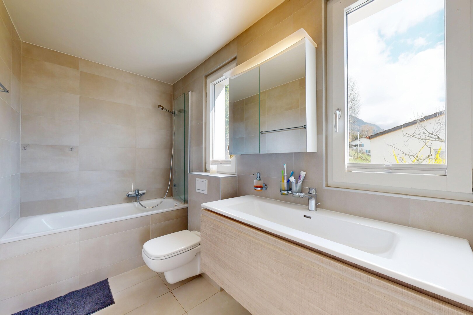 bad mit komplettes badezimmer, toilette, light floor, spiegel, und kombiniertes bad / dusche