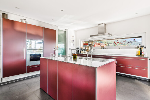 küche mit red cabinets, rote schränke, inside property, light countertops, und kitchen island sink
