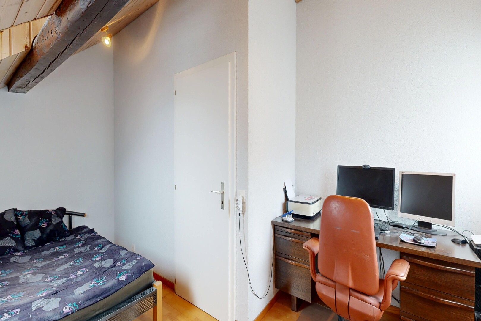 chambre avec inside property, télévision, cloison sèche, drywall, et sol en finition bois