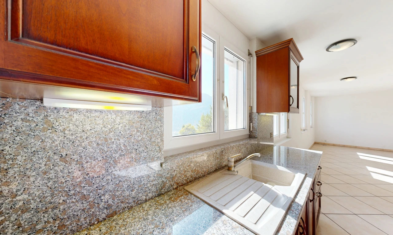 cuisine avec light floor, armoires avec moulures, crown molding cabinets, light countertops, et armoires marron moyen