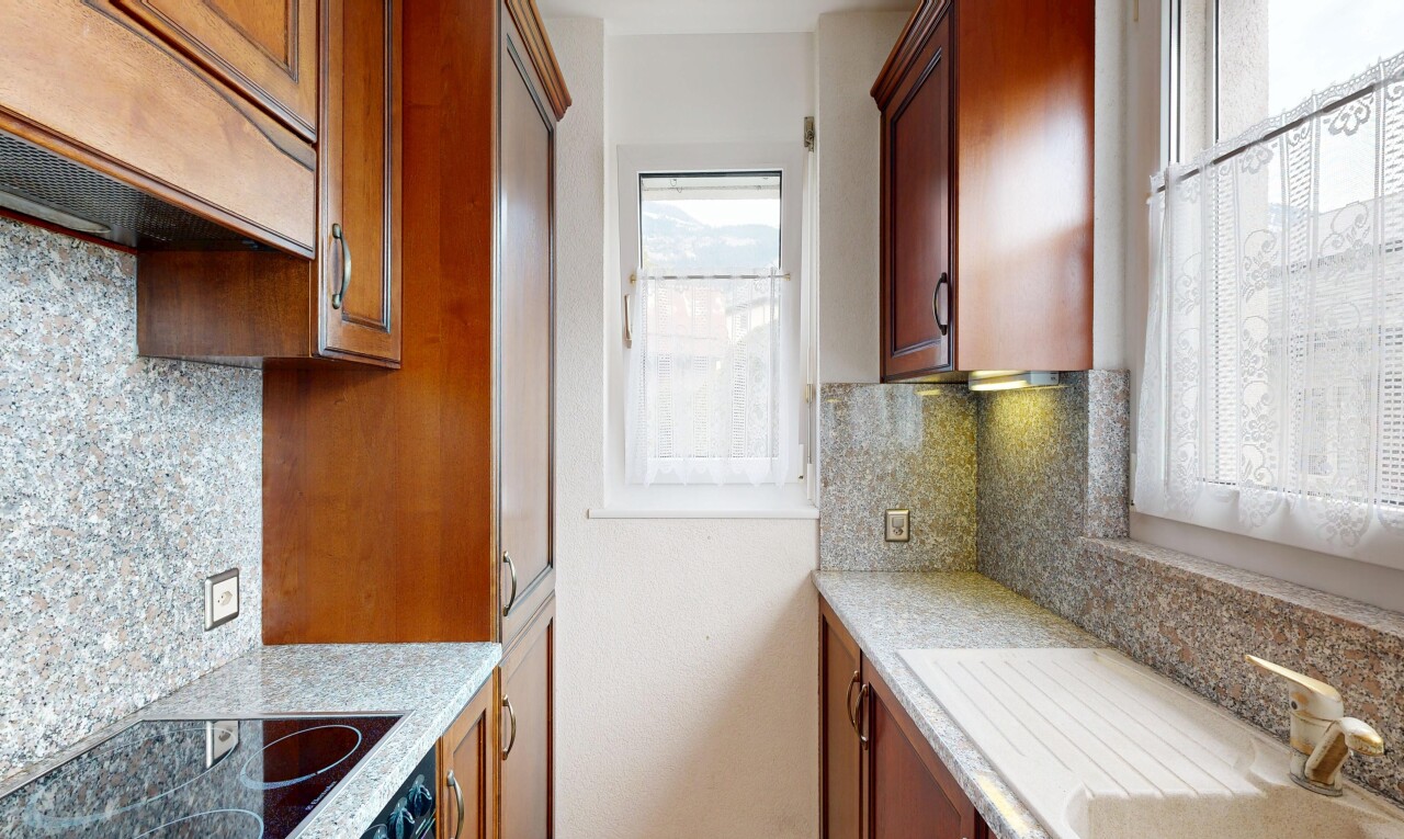 cuisine avec dosseret, backsplash, hotte, light countertops, et plaque de cuisson