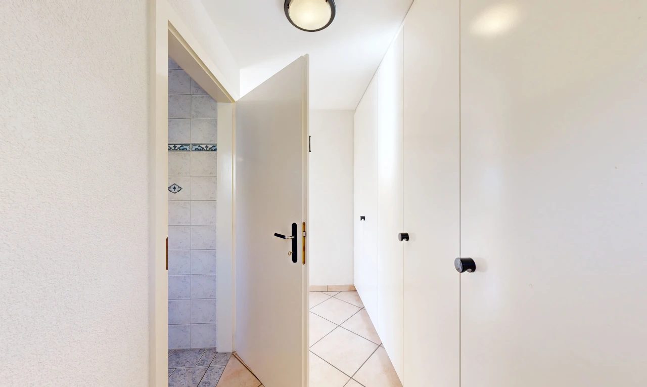 couloir avec light floor, tile floor, sol en carrelage, et inside property
