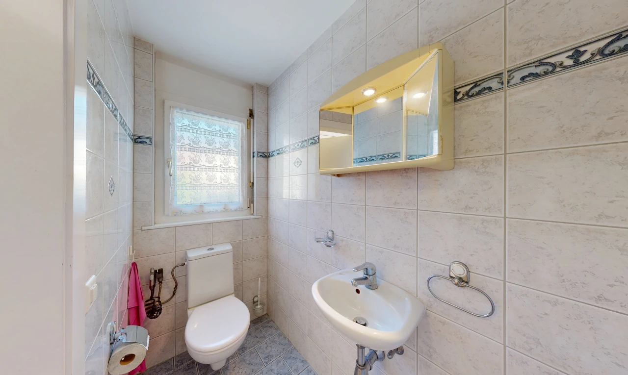 salle de bains avec miroir, toilette, tile wall, mur en carrelage, et évier