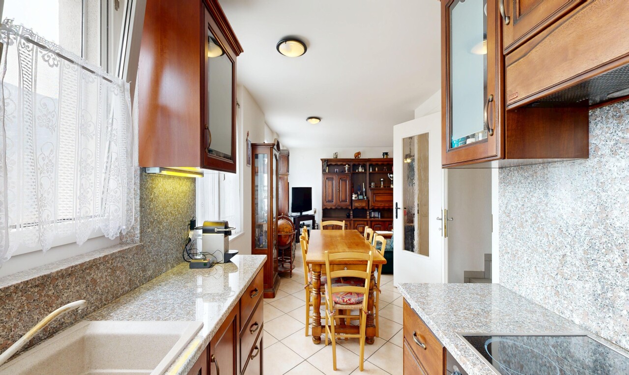 cuisine avec dosseret, backsplash, plans de travail en pierre, stone countertops, et armoires avec insert en verre