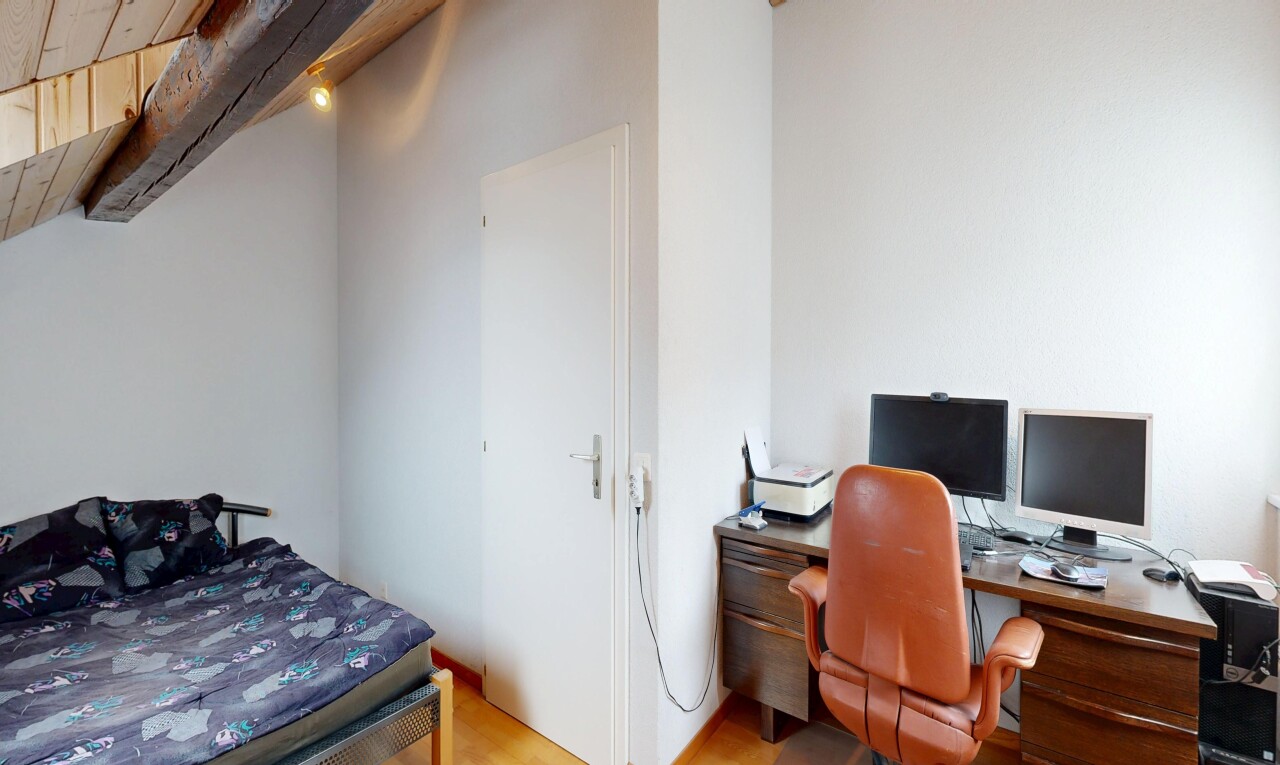chambre avec inside property, télévision, cloison sèche, drywall, et sol en finition bois