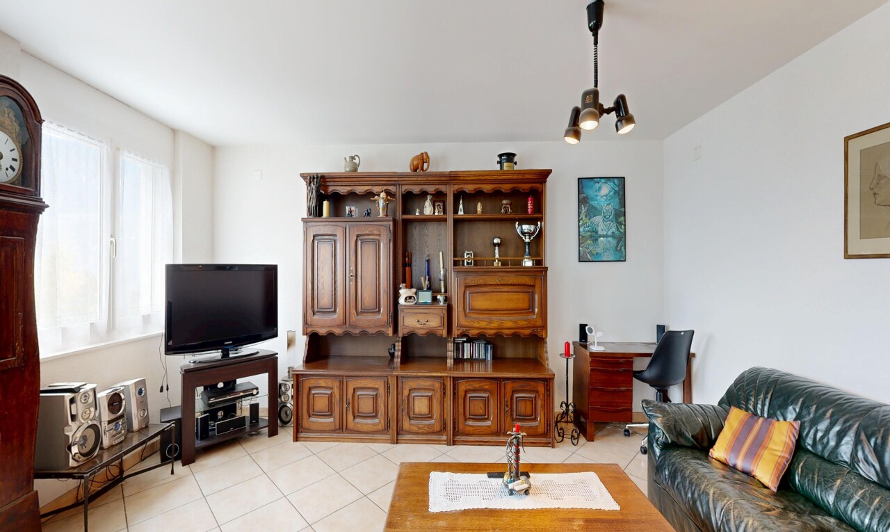 salon avec télévision, inside property, drywall, cloison sèche, et light floor