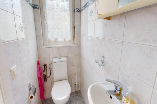 salle de bains avec inside property, toilette, mur en carrelage, tile wall, et lumière naturelle