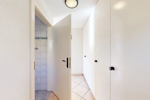 couloir avec light floor, tile floor, sol en carrelage, et inside property