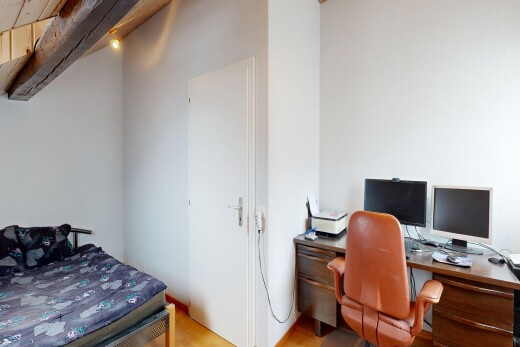 chambre avec inside property, télévision, cloison sèche, drywall, et sol en finition bois