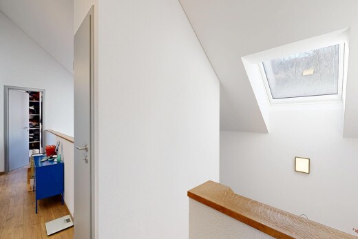 couloir avec inside property, cloison sèche, drywall, puits de lumière, et sol en finition bois