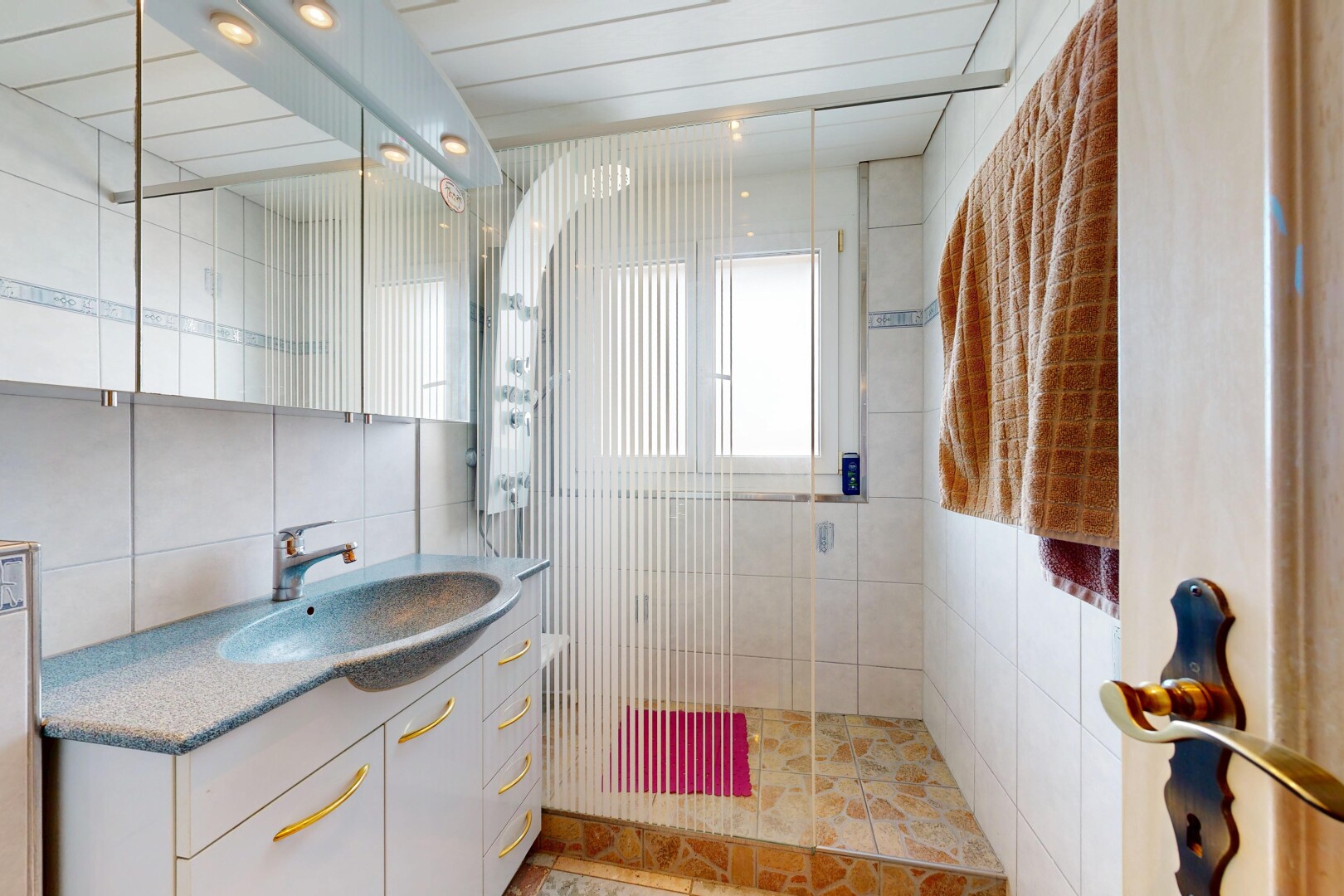 bad mit dusche, schminktisch, komplettes badezimmer, waschbecken, und fliesenwand