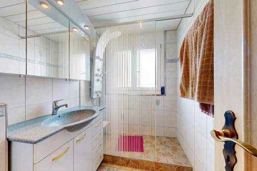 bad mit dusche, schminktisch, komplettes badezimmer, waschbecken, und fliesenwand